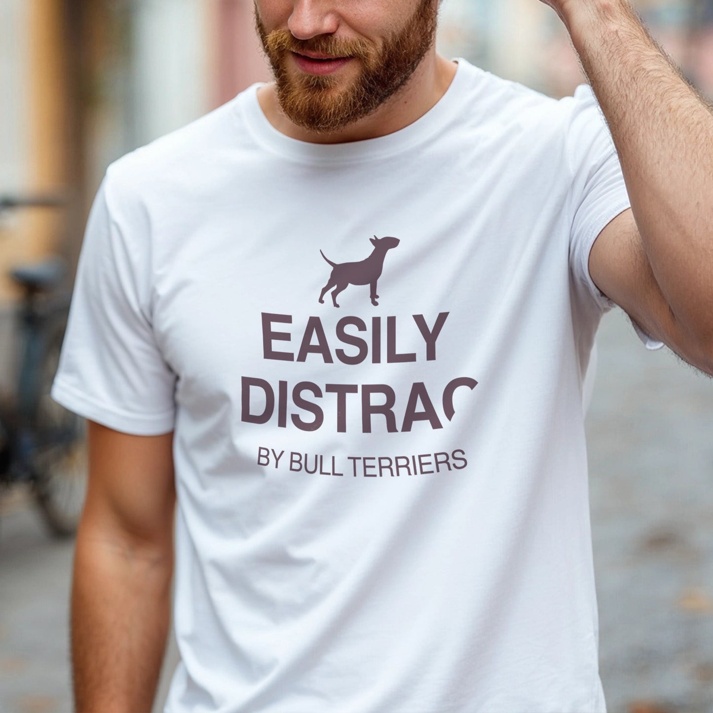 Man wearing a white t-shirt with text and a dog graphic reading EASILY DISTRACTED BY BULL TERRIERS