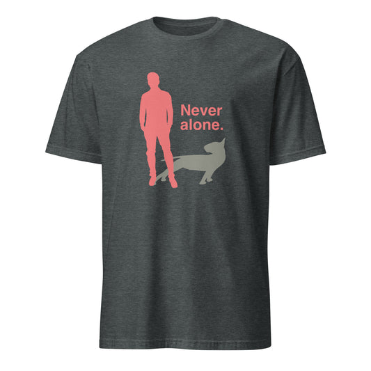 Product mockup of a dark grey t-shirt with a graphic of a red figure and grey bull terrier shadow, and the text 'Never alone.' on a city street.