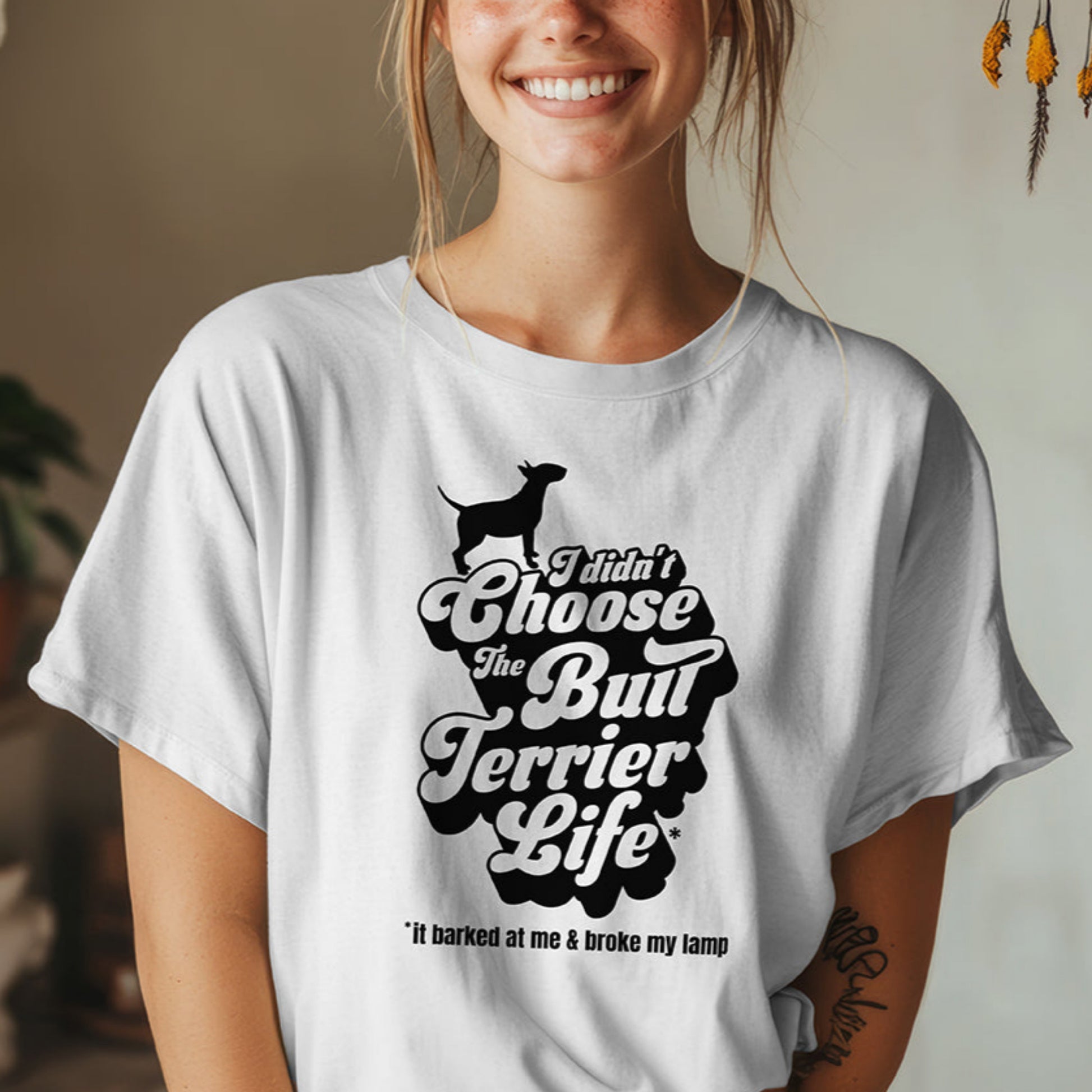 Woman wearing a white t-shirt with a graphic and text, "I didn't choose the Bull Terrier Life, it barked at me and broke my lamp".