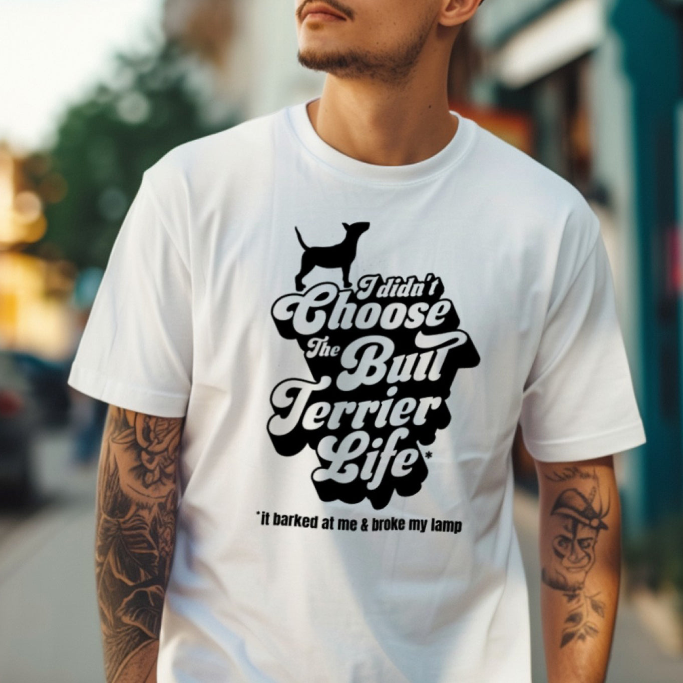 Person wearing a white t-shirt with a black graphic and text "I didn't choose the Bull Terrier Life, it barked at me and broke my lamp".