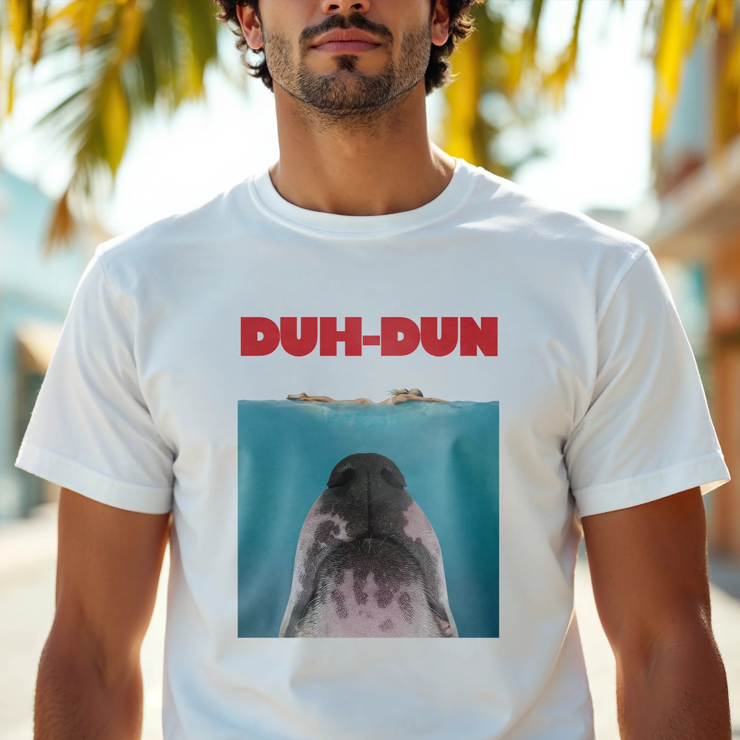 Man wearing a white t-shirt with a parody graphic inspired by the JAWS movie poster of a dog's face and 'DUH-DUN' text
