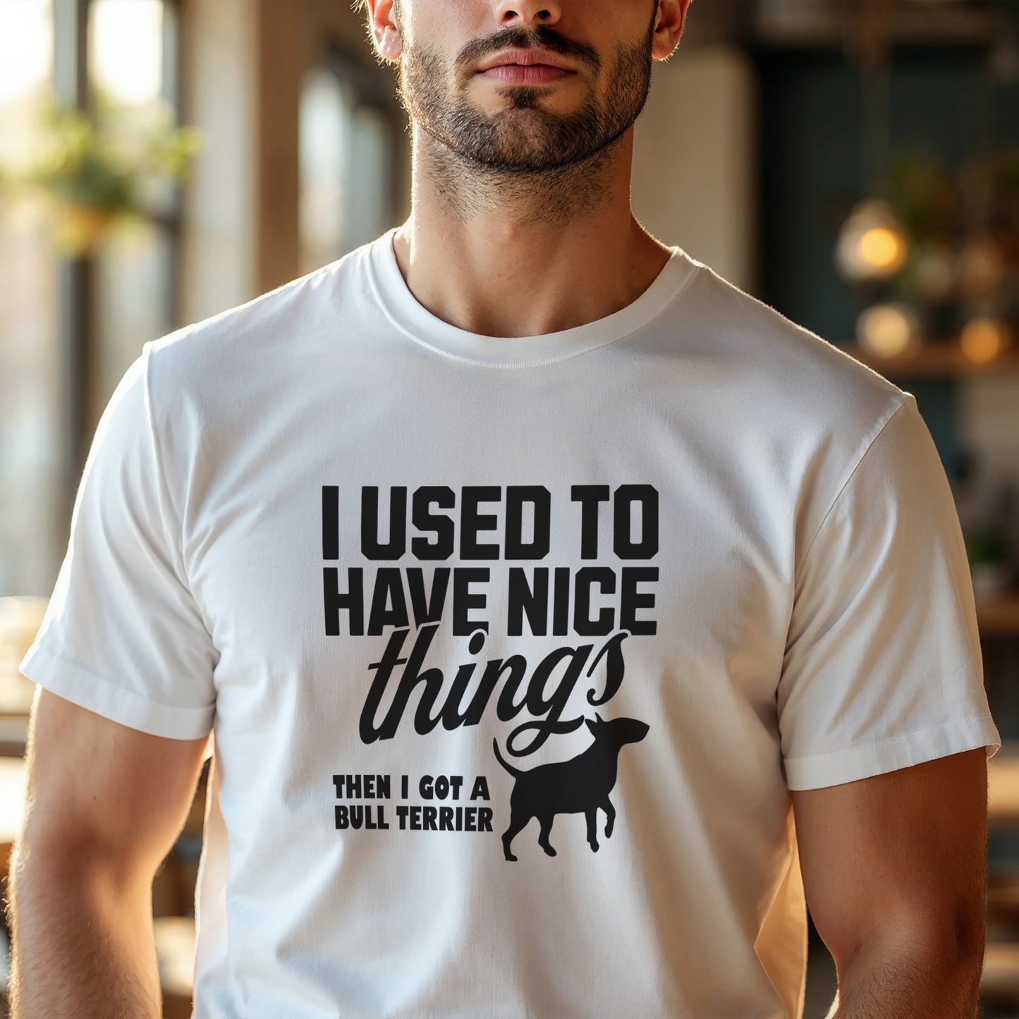 Man wearing a white t-shirt with a humorous text design about a Bull Terrier, "I used to have nice things, then i got a Bull Terrier".