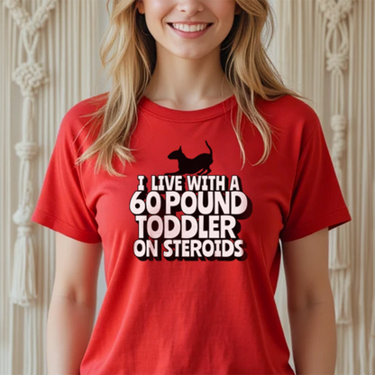 Person wearing a red t-shirt with a graphic of a bull terrier and text "I' Live with a 60-Pound toddler on steroids"
