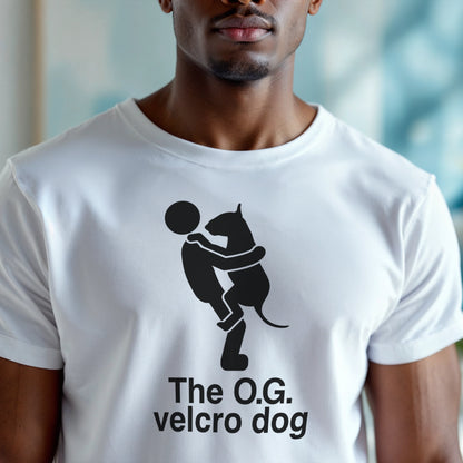 Person wearing a white t-shirt with a graphic of a bull terrier jumping into a persons arms, and text 'The O.G. velcro dog'.