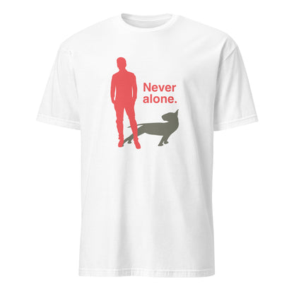 Product mockup of a white t-shirt with a graphic of a red figure and grey bull terrier shadow, and the text 'Never alone.' on a city street.